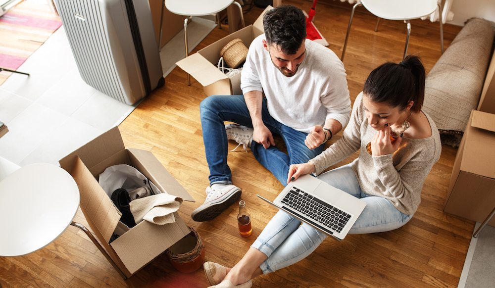 Moving Day Tips | Couple reviews their moving contract while surrounded by packed boxes